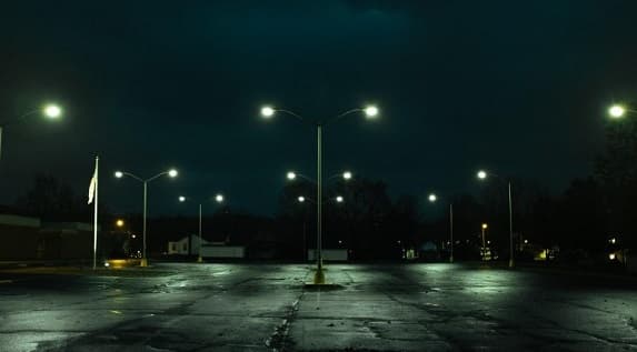Rows of parking lot light poles at dusk