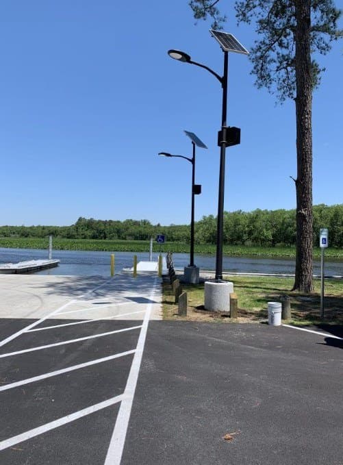 Solar LED light installed along a rural park pathway near a boat launch