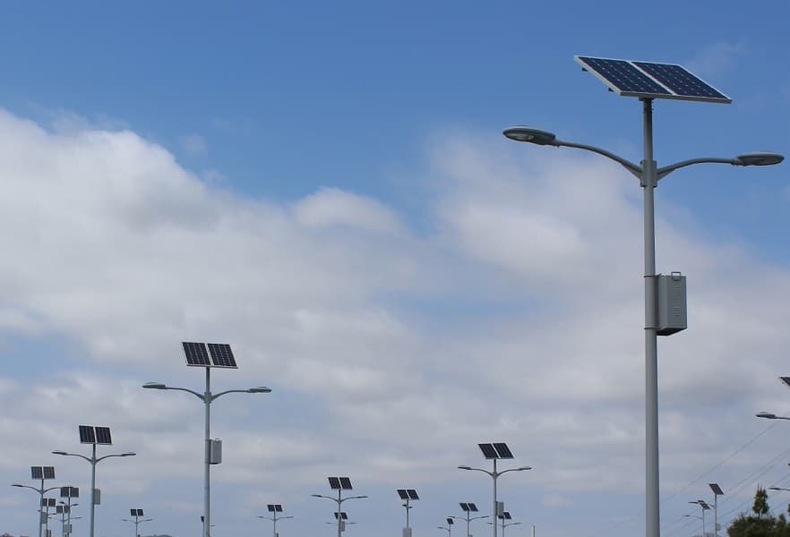 Solar-powered parking lot light fixtures at dusk