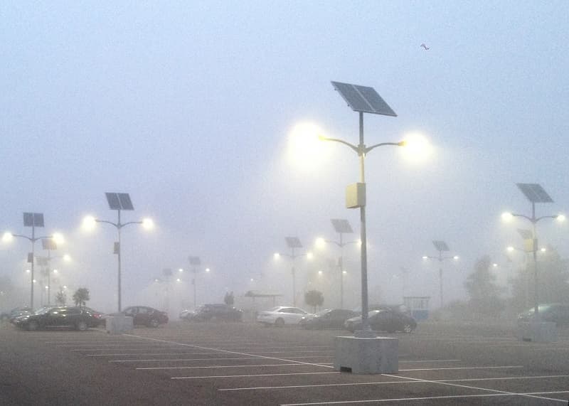 Illuminated solar-powered parking lot light at night