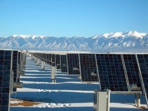 Solar panel angled toward the sun in a cold, mountainous landscape